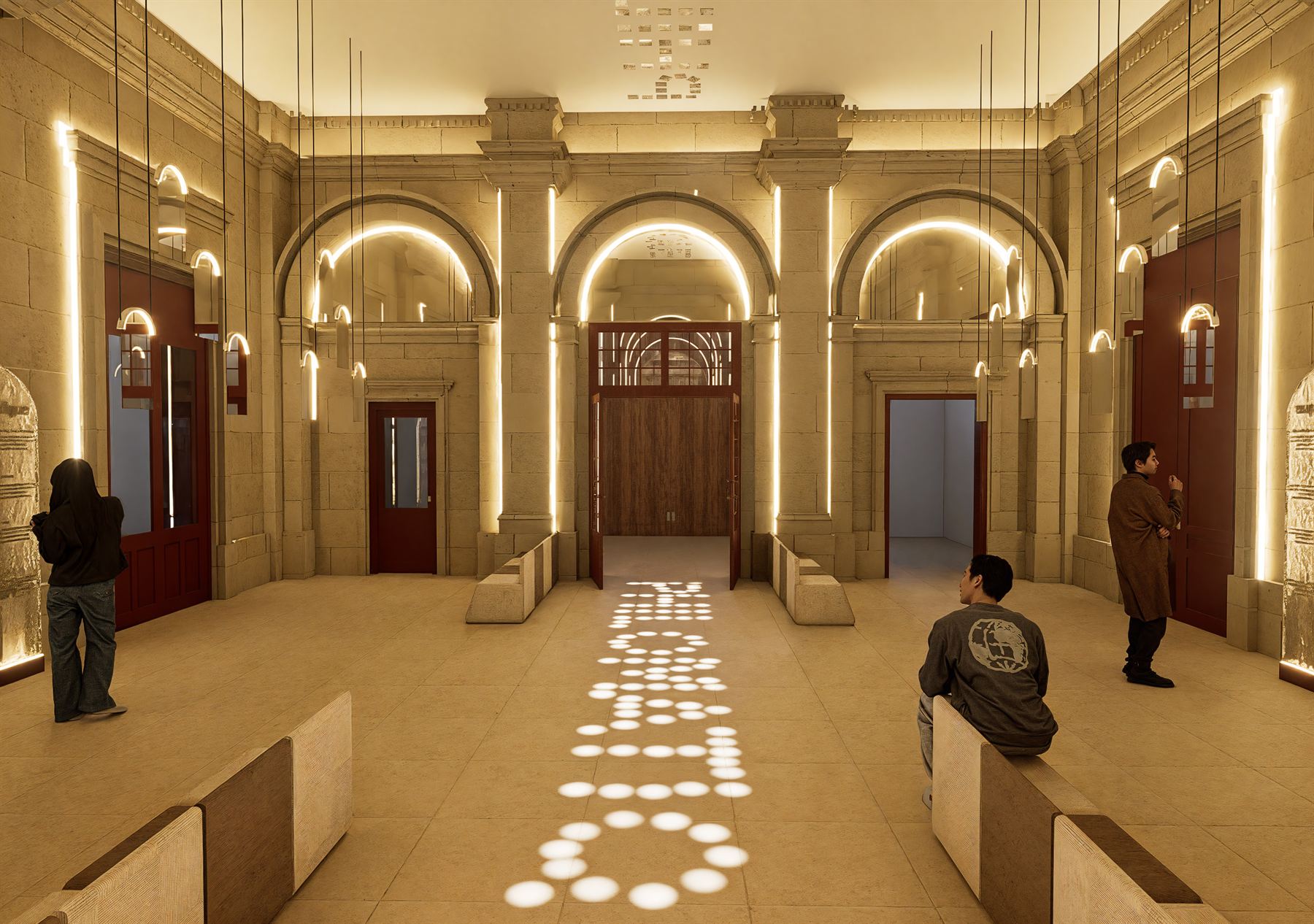 Le hall : arcs de pierre soulignés de LED et lettrage Philomathique projeté au sol