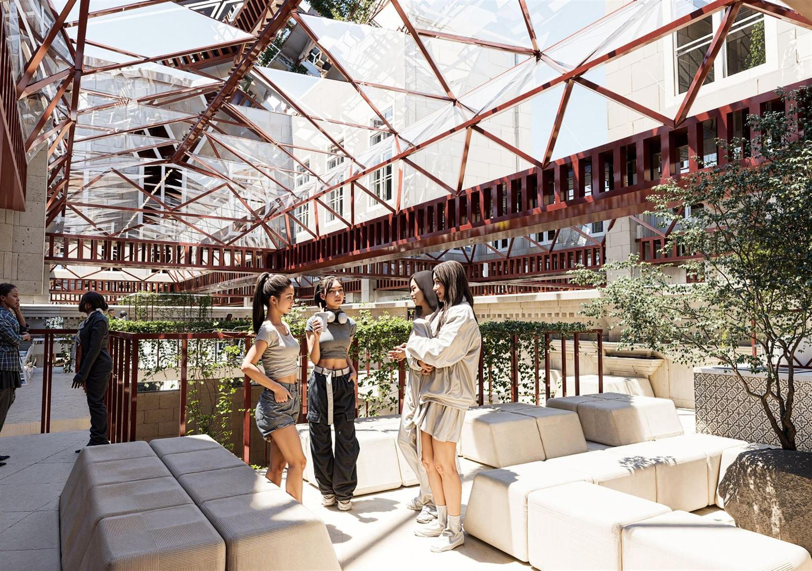 Passerelle de la verrière, assises claires et végétation sous la charpente rouge